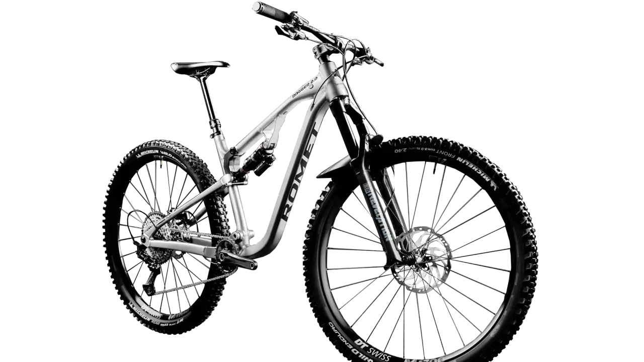 Srebrny rower górski full-suspension, model Dagger 2.0, z oponami Michelin Wild Enduro. Idealny do jazdy po trudnym terenie, czyli właśnie mtb co to.