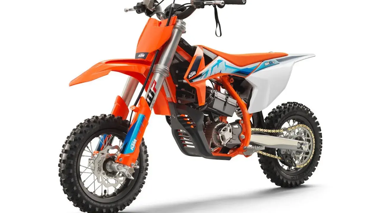 Pomarańczowy motocykl KTM SX-E 5, idealny dla młodych adeptów motocrossu. To świetny sposób, by zacząć przygodę z tym sportem i poznać, co to KTM.