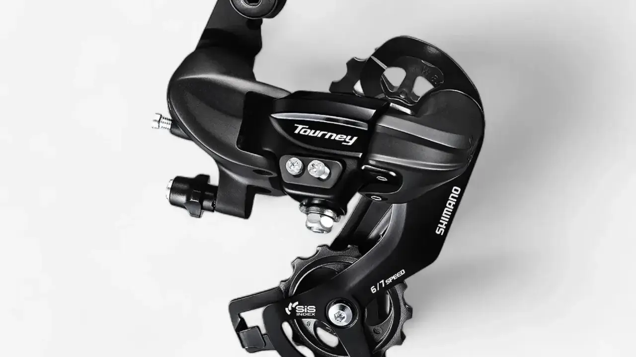 Czarny, tylny przerzutka Shimano Tourney SIS 6/7 Speed. Dowiedz się, jak zmieniać przerzutki w rowerze szosowym, by jazda była płynniejsza.