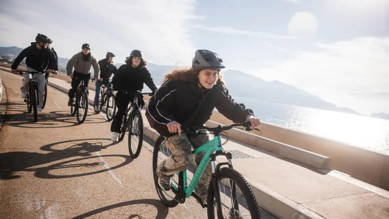 Grupa przyjaciół na rowerach cieszy się słonecznym dniem. Ich wspólny coffee ride nad morzem to idealny sposób na aktywny wypoczynek.
