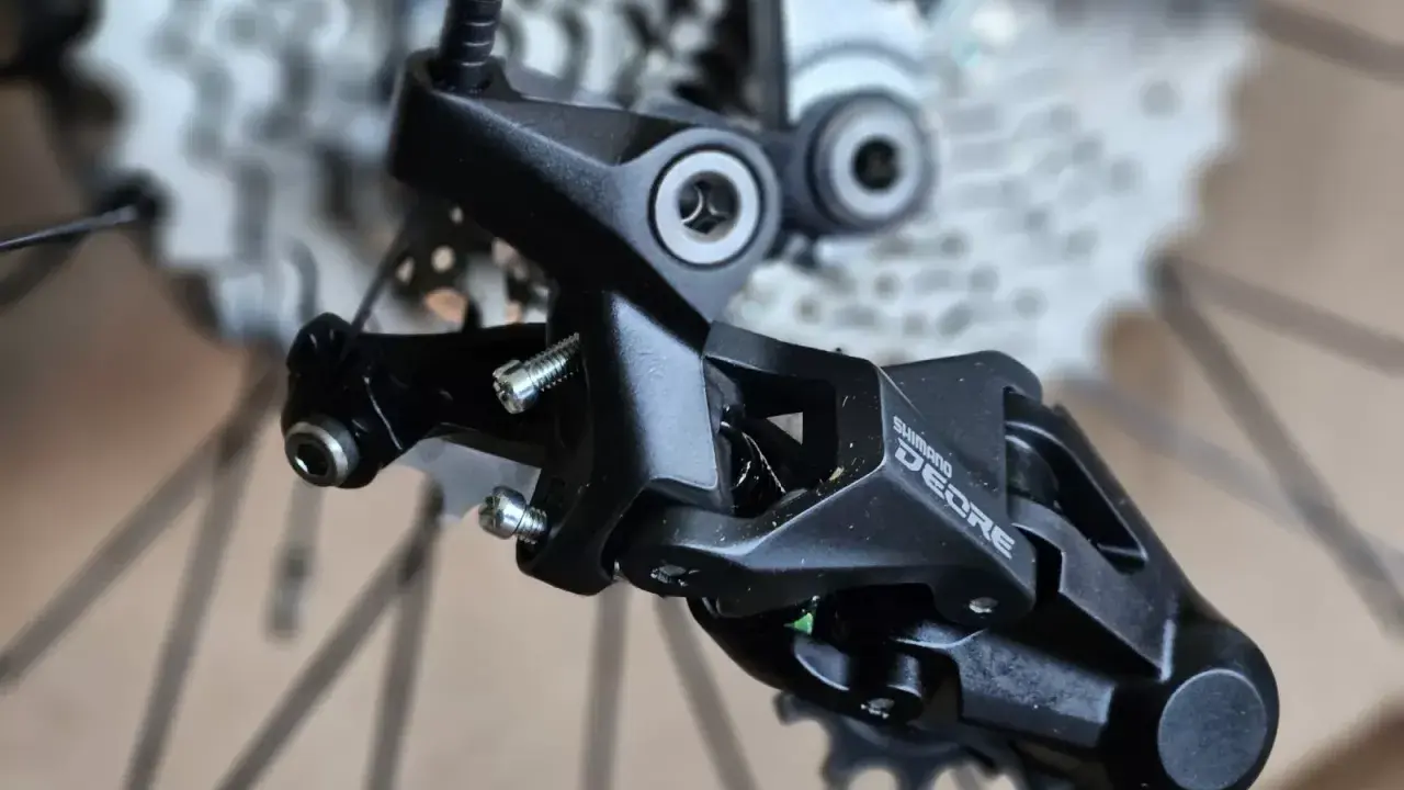 Precyzyjne mocowanie tylnej przerzutki Shimano Deore, gotowe do montażu na rowerze.