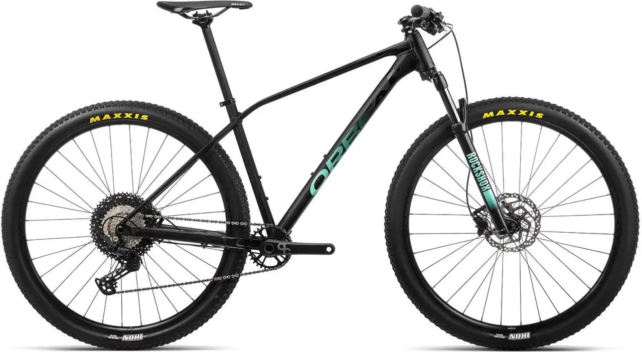 Czarny rower górski Orbea z zielonym logo. Opony Maxxis, amortyzator RockShox.
