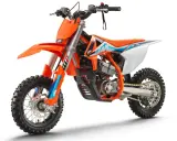 Pomarańczowy motocykl KTM SX-E 5, idealny dla młodych adeptów motocrossu. To świetny sposób, by zacząć przygodę z tym sportem i poznać, co to KTM.