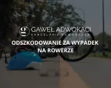 Uszkodzony rower i kask leżą na drodze po wypadku na rowerze. Kancelaria prawna oferuje odszkodowanie.