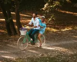Szczęśliwa para na rowerze w parku. Rama 17 cali na jaki wzrost? Idealna na romantyczny spacer.