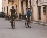 Para jazda na rowerze w 10 stopniach: mężczyzna w krótkim rękawku i szortach, kobieta w kurtce.