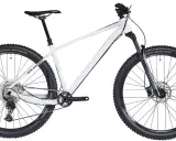 Biały rower hardtail z szerokimi oponami i amortyzatorem RockShox, gotowy na terenowe wyzwania.