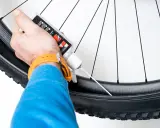 Rowerzysta uzupełnia płyn uszczelniający do koła bezdętkowego.