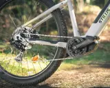 Szary rower elektryczny STILUS OFFROAD z widocznym napędem i pedałami, gotowy na leśne ścieżki.