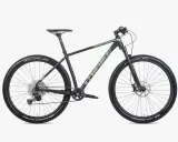 Czarny rower górski Unibike Evo z zielonymi akcentami, oponami Schwalbe Racing Ralph i Ray, gotowy na przygodę.