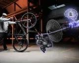 Mężczyzna z rowerem, obok którego widać zaawansowany napęd z mózgiem AI. To pokazuje, co to za firma Unibike – innowacje w rowerach.
