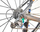 Tylna przerzutka Shimano Ultegra, kluczowy element przekładni rowerowej, na tle koła i ramy Orbea.