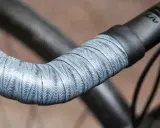 Wyjątkowa owijka na kierownicę roweru z falistym wzorem w odcieniach szarości i bieli.