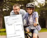 Ojciec i syn na rowerach, z dokumentem "Karta Rowerowa". Dzięki niej można jeździć na rowerze.