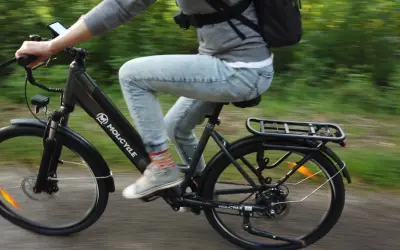Osoba na rowerze elektrycznym Molicyle, jadąca po ścieżce. Dowiedz się, jak wybrać rower elektryczny.
