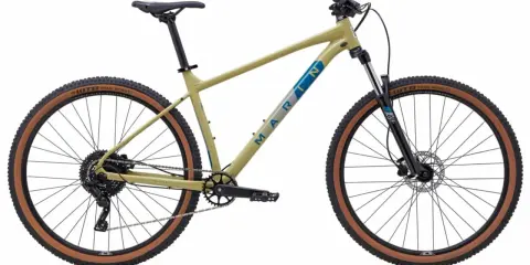 Beżowy rower trailowy Marin z brązowymi oponami WTB Trail Boss gotowy na przygodę.