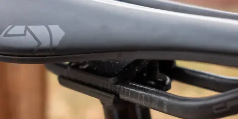Szukasz idealne siodełko do mtb? Zobacz zbliżenie na czarne siodełko rowerowe z logo i oznaczeniami regulacji.