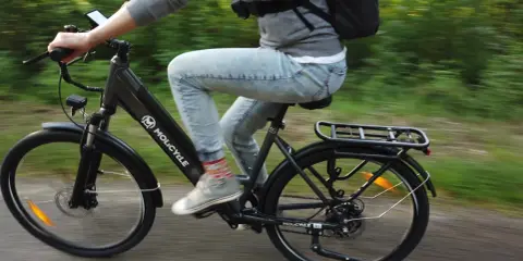 Osoba na rowerze elektrycznym Molicyle, jadąca po ścieżce. Dowiedz się, jak wybrać rower elektryczny.
