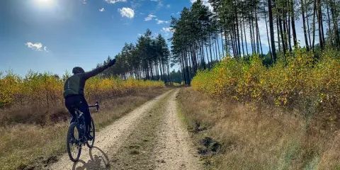 Rowerzysta na szutrowej drodze, cieszący się jesiennym krajobrazem. To prawdziwy gravel po łódzku, z dala od miejskiego zgiełku.