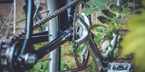 Zbliżenie na rowerowy napęd: korba, zębatka i łańcuch. Dowiedz się, jak dobrać długość łańcucha rowerowego, by jazda była płynna.