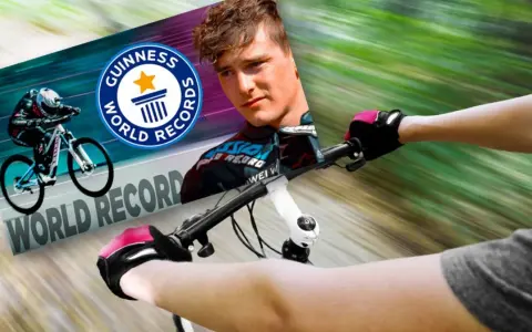 Kolarz w rękawiczkach ściga się na rowerze, celując w rekord prędkości na rowerze, z logo Guinness World Records.