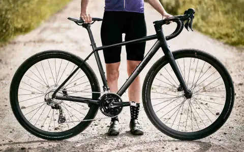Czarny rower gravel turystyczny na szutrowej drodze, gotowy na przygodę.