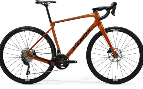 Pomarańczowy rower gravelowy Merida Silex 4000 z napędem Shimano GRX i oponami Maxxis Rambler.