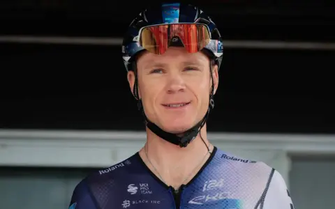 Uśmiechnięty kolarz w kasku i goglach, gotowy do walki o tytuł jednego z tour de france zwycięzcy.