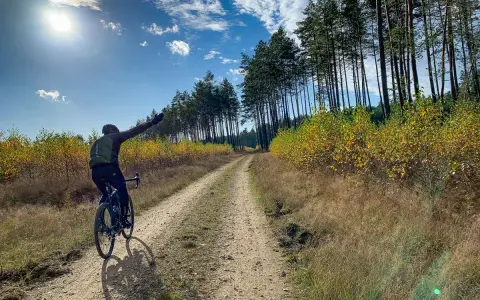 Rowerzysta na szutrowej drodze, cieszący się jesiennym krajobrazem. To prawdziwy gravel po łódzku, z dala od miejskiego zgiełku.