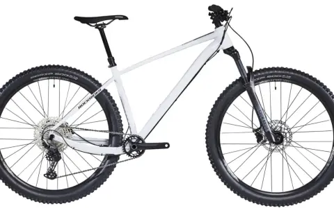 Biały rower hardtail z szerokimi oponami i amortyzatorem RockShox, gotowy na terenowe wyzwania.