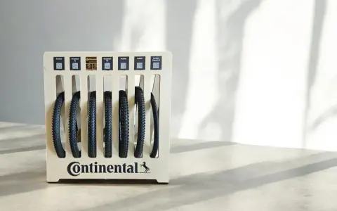 Stojak z oponami rowerowymi Continental. Różne modele, np. Xynotal, Kryptotal, Argotal. Rozmiar 700x35c to popularny wybór dla rowerów szosowych i gravelowych.