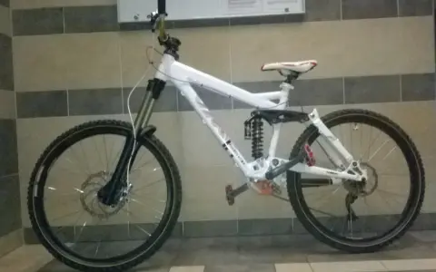 Biały rower zjazdowy z pełnym zawieszeniem i napędem 2x9, gotowy na trudne trasy.