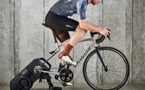 Kolarz na trenażerze, ćwiczący jak zwiększyć pojemność płuc. Intensywny trening cardio dla lepszej wydolności.
