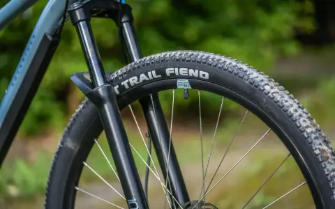 Opona rowerowa "Trail Fiend" z widocznym bieżnikiem, zwijana, gotowa na terenowe wyzwania.
