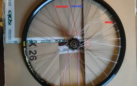 Koło rowerowe 36 szprych, z zaznaczonymi nowymi i starymi szprychami oraz wentylem.