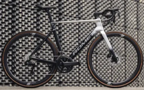 Nowoczesny rower szosowy marki Romet z osprzętem Shimano Ultegra, prezentujący się na tle geometrycznej ściany.