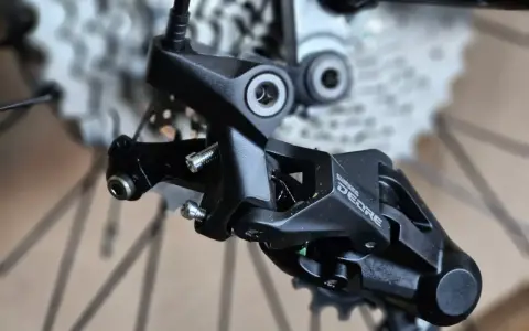 Precyzyjne mocowanie tylnej przerzutki Shimano Deore, gotowe do montażu na rowerze.