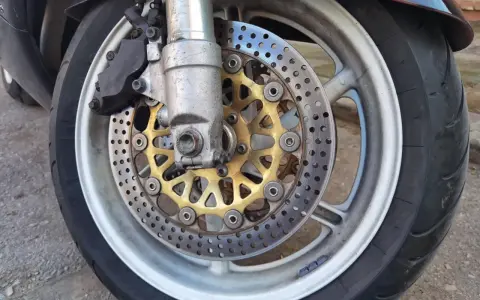 Motocykl z tarczami hamulcowymi i zaciskiem. Ostre koło hamowanie zapewnia bezpieczeństwo na drodze.