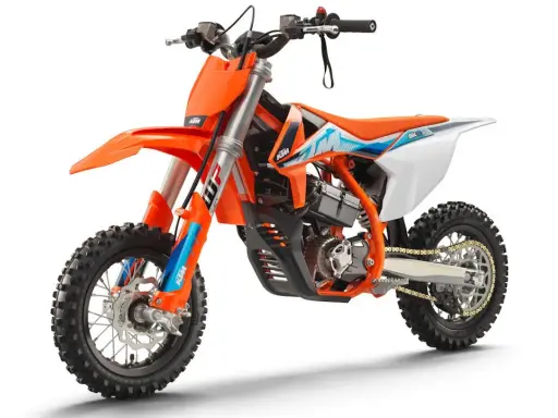 Pomarańczowy motocykl KTM SX-E 5, idealny dla młodych adeptów motocrossu. To świetny sposób, by zacząć przygodę z tym sportem i poznać, co to KTM.