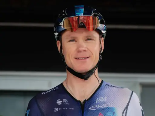 Uśmiechnięty kolarz w kasku i goglach, gotowy do walki o tytuł jednego z tour de france zwycięzcy.