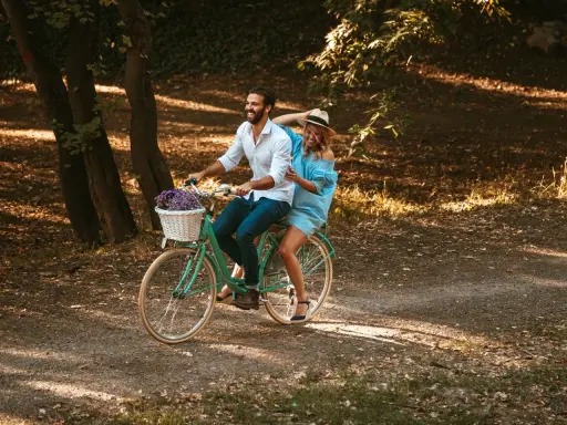 Szczęśliwa para na rowerze w parku. Rama 17 cali na jaki wzrost? Idealna na romantyczny spacer.