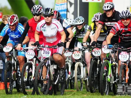 Zawodnicy w kaskach i strojach kolarskich startują w wyścigu mtb bike maraton.