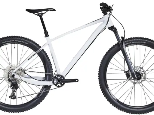 Biały rower hardtail z szerokimi oponami i amortyzatorem RockShox, gotowy na terenowe wyzwania.