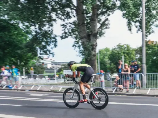 Kolarz w stroju sportowym ściga się na rowerze aerodynamicznym. Myślę, jak sprzedać rower, gdy widzę takie osiągi.