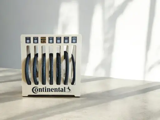 Stojak z oponami rowerowymi Continental. Różne modele, np. Xynotal, Kryptotal, Argotal. Rozmiar 700x35c to popularny wybór dla rowerów szosowych i gravelowych.