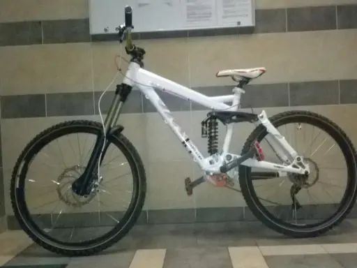 Biały rower zjazdowy z pełnym zawieszeniem i napędem 2x9, gotowy na trudne trasy.