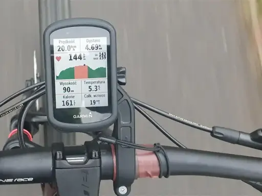 Na rowerze zamontowany licznik Garmin pokazuje dane treningowe: prędkość 20 km/h, dystans 4.69 km, tętno 144 bpm. Analiza stref tętna kolarstwo jest kluczowa.