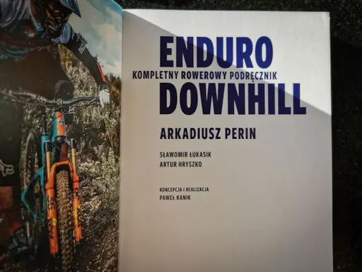 Książka "Enduro Kompletny Rowerowy Podręcznik Downhill" z rowerzystą w akcji. Dowiedz się, co to downhill!