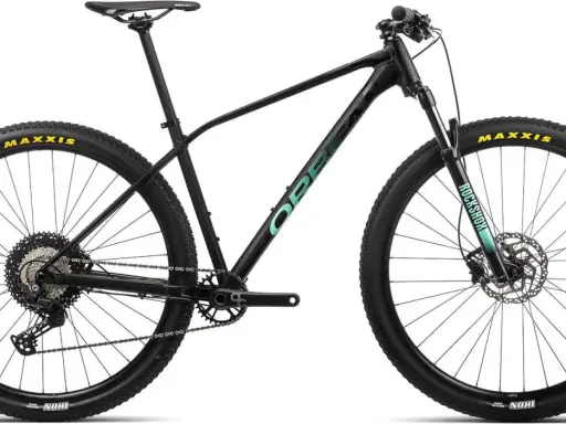 Czarny rower górski Orbea z zielonym logo. Opony Maxxis, amortyzator RockShox.