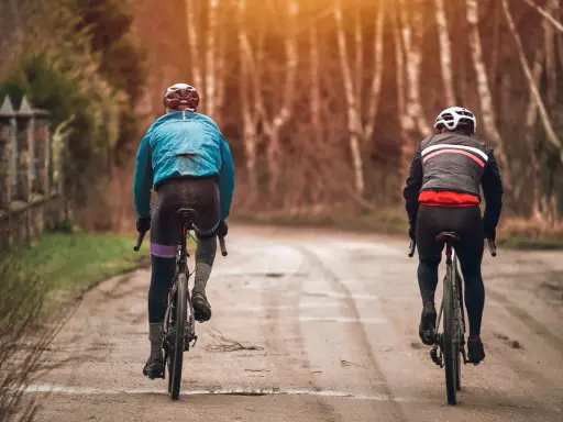 Dwóch rowerzystów w jesiennych strojach, idealnych na 15 stopni. Lekka kurtka i długie spodenki to dobry wybór na przejażdżkę.